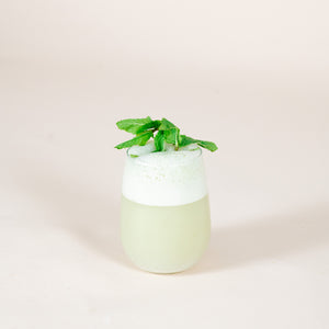
                  
                    A pale-green mocktail with a sprig of mint sits on a table. The drink was made using the FYXX Bones Drink Mix.
                  
                